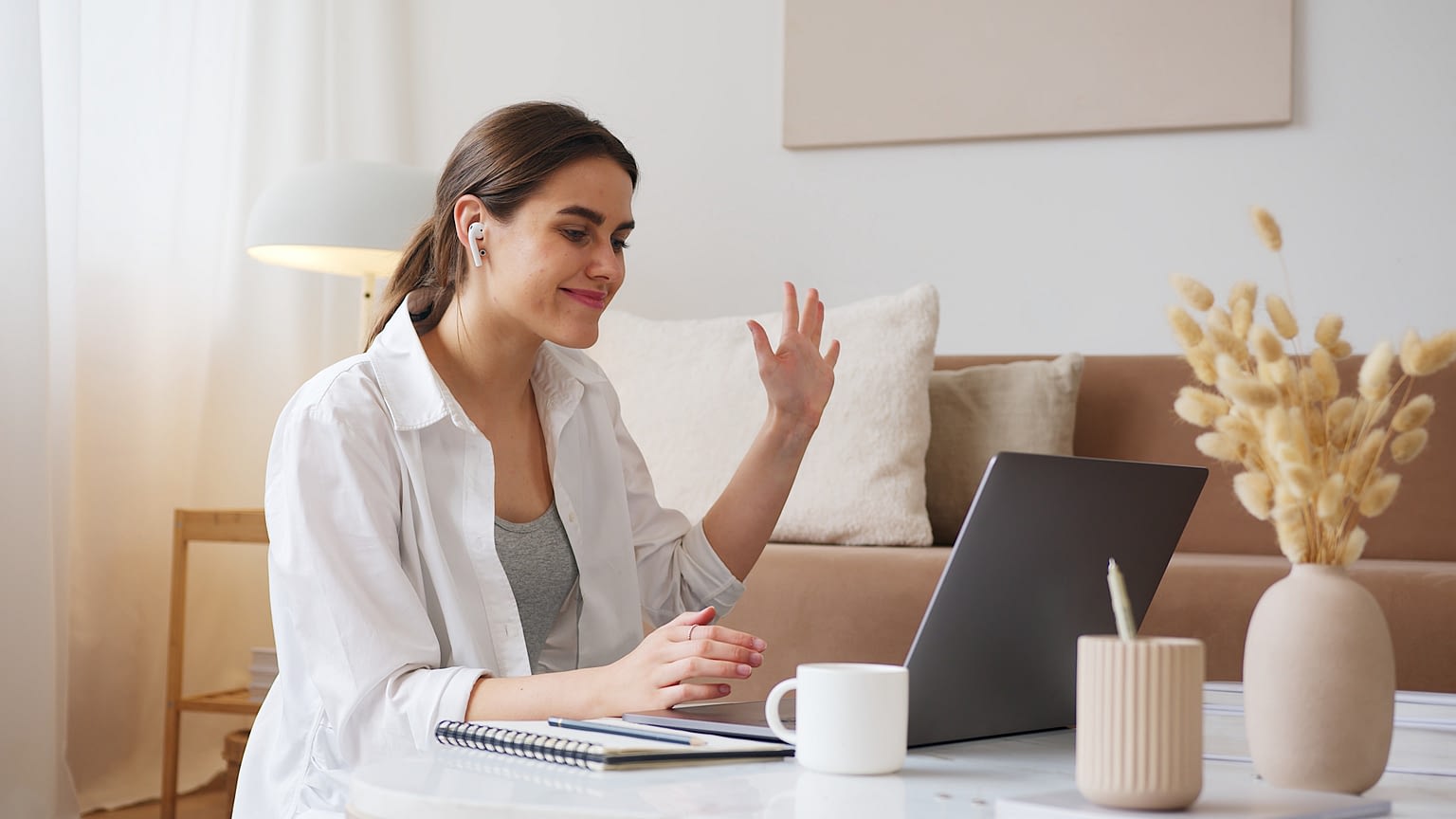 Freelance online English teacher waving to her student.